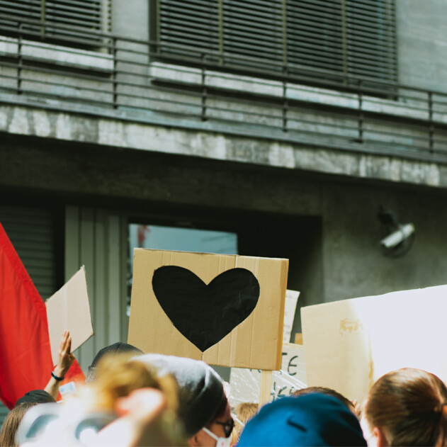 folla di gente che protesta davanti a un edificio