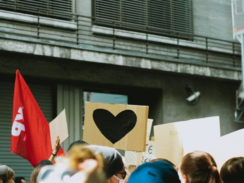 folla di gente che protesta davanti a un edificio